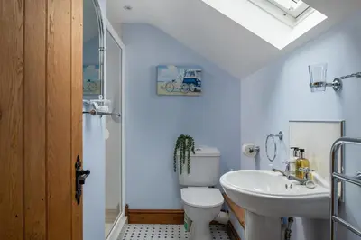 a bathroom with a white toilet and a sink at Ysgoldy in Llanfor