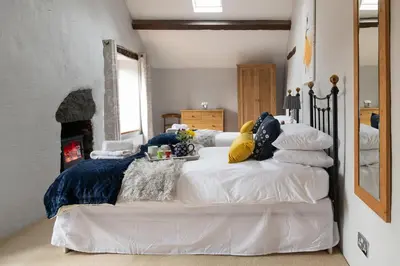 a bedroom with a bed with pillows on it at Ysgoldy in Llanfor