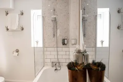a white bathroom with a tub and a shower at RiverTree House in Llangollen