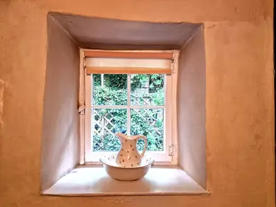 a window with a vase sitting on a window sill at Arwel in New Quay