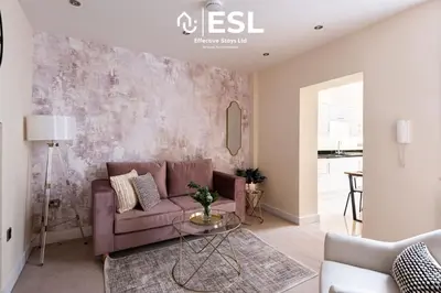 a living room with a purple couch and a table at Super Central - Quiet - 2 Bedroom Cottage in Shrewsbury