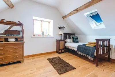 a bedroom with a bed and a dresser in a attic at ryton grange church barn sleeps 5 in Shrewsbury