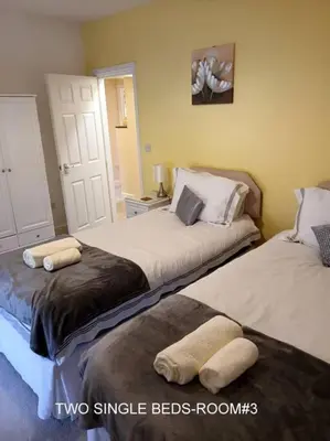 two beds in a room with two single beds at Harlech/HUGE Three bedroom/BEST location in Llanbedr