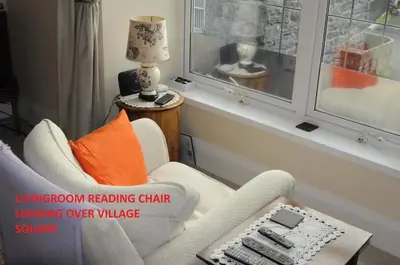 a living room with a living room reading chair looking over a window at Harlech/HUGE Three bedroom/BEST location in Llanbedr