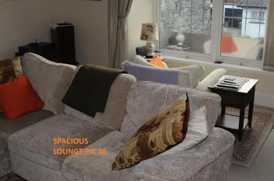 a living room with a couch with pillows on it at Harlech/HUGE Three bedroom/BEST location in Llanbedr