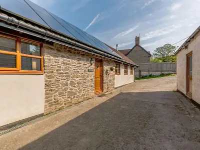 an old stone building with a orange door on it at Stone Cottage in Shrewsbury
