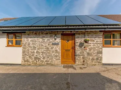 a house with a solar roof on top of it at Stone Cottage in Shrewsbury