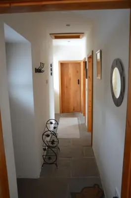 a hallway leading to a hallway with a door and stairs at Stone Cottage in Shrewsbury