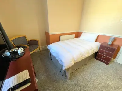 a small bedroom with a bed and a desk at The Sandbanks in Barmouth