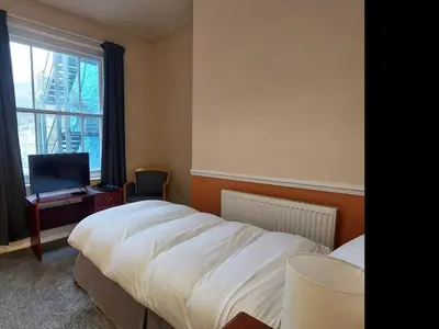 a bedroom with a bed and a desk and a window at The Sandbanks in Barmouth