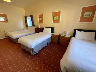a hotel room with two beds with white sheets at The Sandbanks in Barmouth