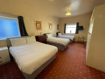 a hotel room with two beds and a television at The Sandbanks in Barmouth