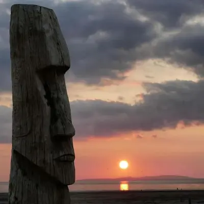 a statue of a head with the sunset in the background at Harbourside 2 Bed apartment, Barmouth Bridge Views in Barmouth