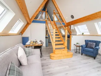 a living room with a staircase in a loft at Hill Radnor - The Sheepfold in Llandrindod Wells