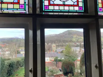 a window with a view of a sheep in a city at The Views Bed and Breakfast in Llangollen