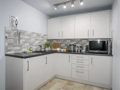 a white kitchen with white cabinets and a microwave at Vyrnwy Lakeside - Bala Lake in Bala