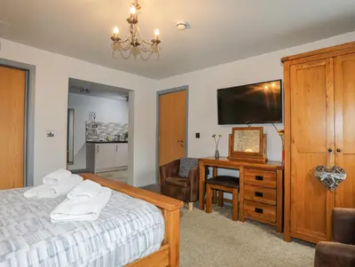 a bedroom with a bed and a desk with a television at Vyrnwy Lakeside - Bala Lake in Bala