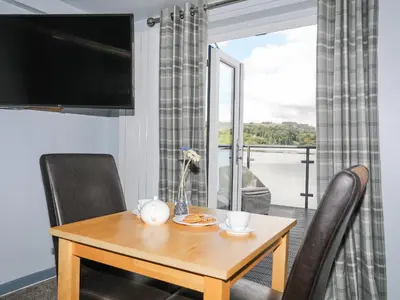 a dining room with a table and chairs and a window at Drysgol Lakeside - Bala Lake in Bala