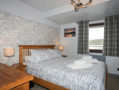a bedroom with a bed and a window at Drysgol Lakeside - Bala Lake in Bala
