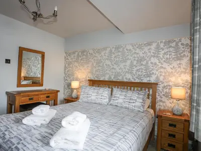 a bedroom with a bed with towels on it at Drysgol Lakeside - Bala Lake in Bala