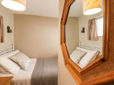 a bedroom with a mirror and a bed at Deu-Ddrws in Barmouth