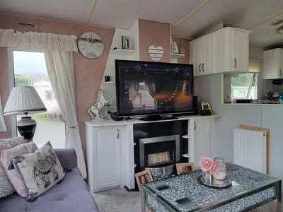 a living room with a tv on top of a fireplace at Caravan - Sleeps 8 pet friendly & hot tub in Welshpool