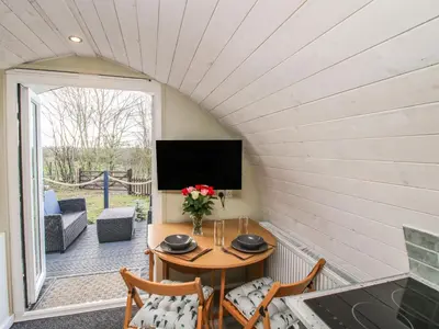 a small room with a table and chairs and a television at Cherry Pod 2 in Shrewsbury