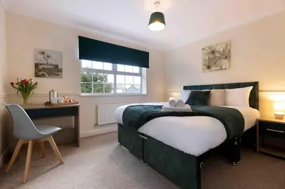 a bedroom with a bed and a desk and a chair at Spacious house in quiet cul-de-sac near to Hospital in Shrewsbury