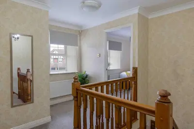 a room with a staircase with a mirror and a window at Spacious house in quiet cul-de-sac near to Hospital in Shrewsbury
