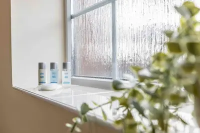 a window with two bottles ofodorizers sitting on a window sill at Spacious house in quiet cul-de-sac near to Hospital in Shrewsbury