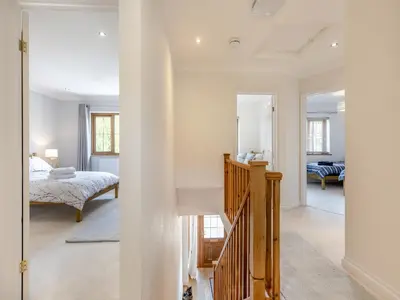 a white room with a bed and a staircase at Dyffryn Cain in Aberystwyth
