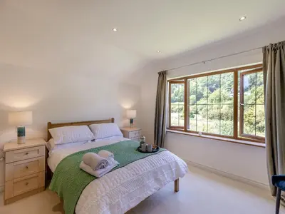 a bedroom with a bed and a large window at Dyffryn Cain in Aberystwyth