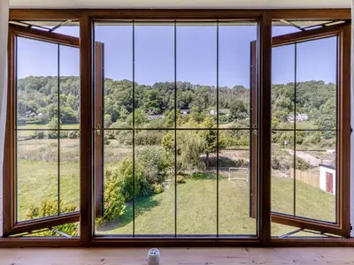 a room with large windows looking out onto a field at Dyffryn Cain in Aberystwyth