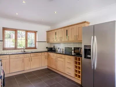 a kitchen with wooden cabinets and a stainless steel refrigerator at Dyffryn Cain in Aberystwyth