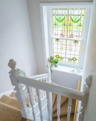 a staircase with a stained glass window and a stair case at Loft Fawr in Tregaron