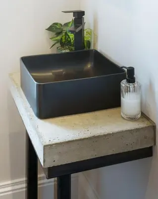 a black sink sitting on a concrete shelf at Loft Fawr in Tregaron