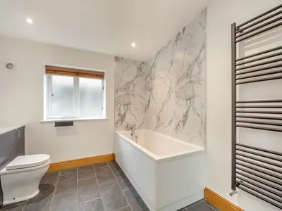 a bathroom with a toilet and a bath tub at Bodwennol - a stunning house! in Aberdyfi