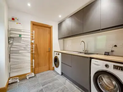 a kitchen with a washing machine and a washer at Bodwennol - a stunning house! in Aberdyfi