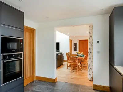 a kitchen and dining room with a dining table at Bodwennol - a stunning house! in Aberdyfi
