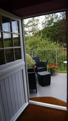a sliding glass door of a porch with two chairs at Top Floor at Cantref House in Brecon