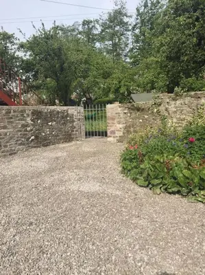 a stone fence with a gate in a garden at Top Floor at Cantref House in Brecon