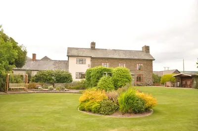 a large brick house with a green yard at Llanhedric House in Clun