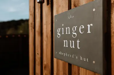 a sign on a wooden fence that reads like ginger nut at The Ginger Nut in Welshpool