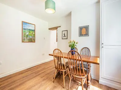 a dining room with a wooden table and chairs at Jackdaw Cottage in Knighton