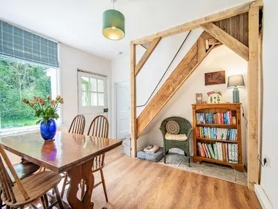 a dining room with a table and a book shelf at Jackdaw Cottage in Knighton