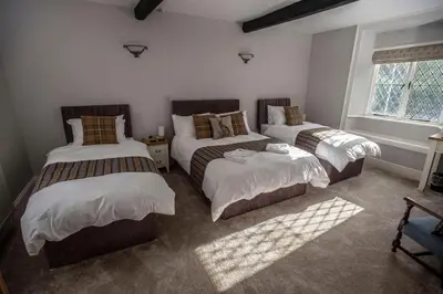a bedroom with three beds and a window at The Berwyn Arms in Corwen