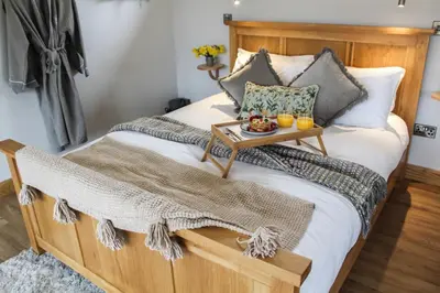 a bed with a wooden frame with a table on it at The Tin Shed in Rhayader