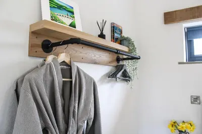 a coat rack hanging on a wall with a towel at The Tin Shed in Rhayader