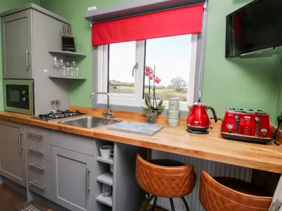 a kitchen with a counter with a sink and a window at Wild Acre in Llangadog