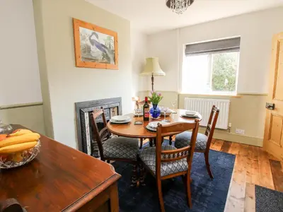 a dining room with a wooden table and chairs at The Ferns in Ludlow